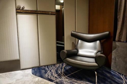 a black leather chair sitting in a bathroom at The Harbourview - Chinese YMCA of Hong Kong in Hong Kong