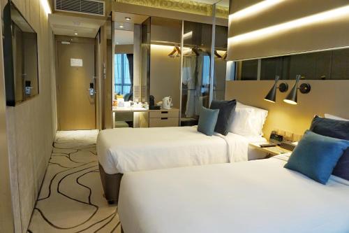 a hotel room with two beds and a bathroom at The Harbourview - Chinese YMCA of Hong Kong in Hong Kong