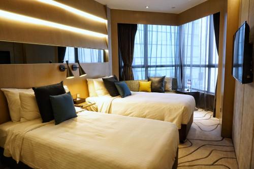a hotel room with two beds and a window at The Harbourview - Chinese YMCA of Hong Kong in Hong Kong