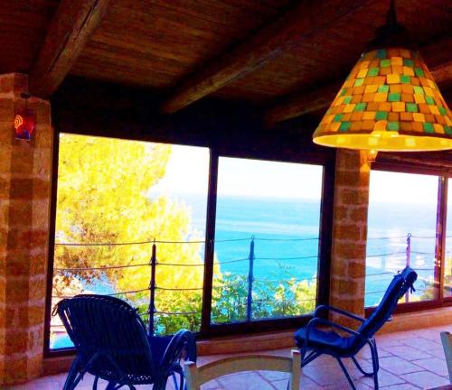 a room with two chairs and a large window at VILLE GIRASOLI "VILLA NELLA BAIA" with PRIVATE SWIMMING POOL in Tricase