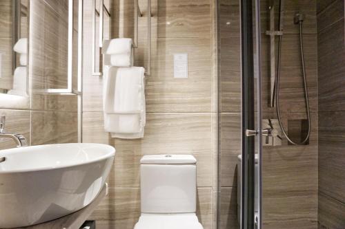 a bathroom with a toilet and a sink and a shower at The Harbourview - Chinese YMCA of Hong Kong in Hong Kong