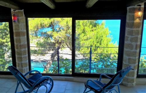 three chairs sitting in front of a large window at VILLE GIRASOLI "VILLA NELLA BAIA" with PRIVATE SWIMMING POOL in Tricase