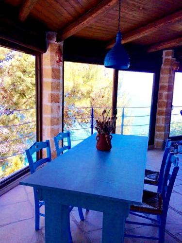 a blue table on a porch with chairs and a potted plant at VILLE GIRASOLI "VILLA NELLA BAIA" with PRIVATE SWIMMING POOL in Tricase