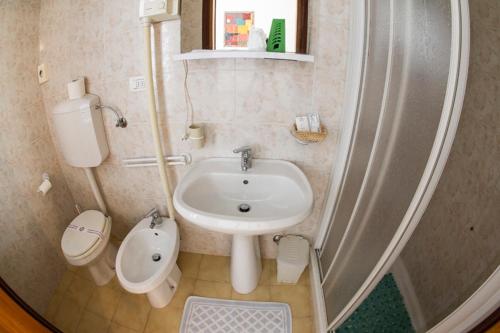 a small bathroom with a sink and a toilet at Dogana Vecchia - Hotel & Residence B&B Ristorante & Pizzeria in Trivignano Udinese