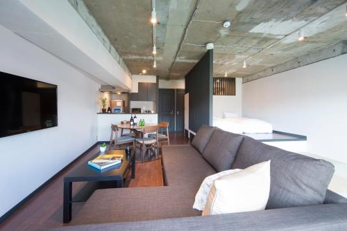 a living room with a couch and a table at A Good Day Fukuoka Riverside in Fukuoka