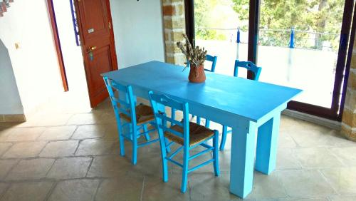 a blue table with two chairs and a vase on it at VILLE GIRASOLI "VILLA NELLA BAIA" with PRIVATE SWIMMING POOL in Tricase