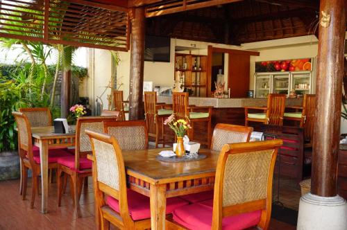 a dining room with a wooden table and chairs at Yulia 2 Homestay Sanur in Sanur