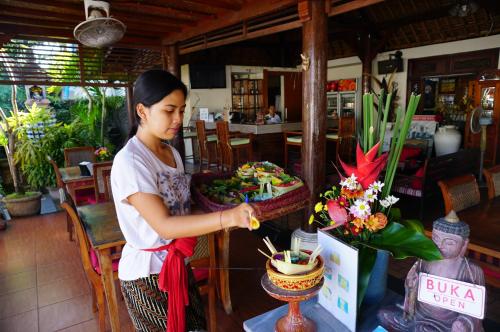 a woman is making a flower arrangement in a store at Yulia 2 Homestay Sanur in Sanur