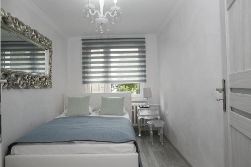 una camera con letto e finestra con lampadario a braccio di Good Station ZAMEK a Malbork