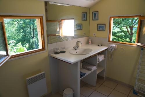 a bathroom with a sink and two windows at Hôtel Restaurant Le Mûrier de Viels - Figeac Grand in Causse et Diege