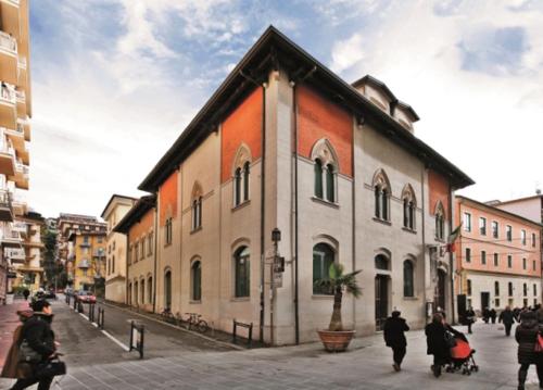 Un groupe de personnes marchant dans une rue à côté d'un bâtiment dans l'établissement Il Ristoro di Garibaldi, à La Spezia