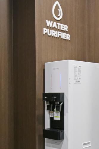 a water purifier machine in front of a water provider sign at Philstay Myeongdong Station in Seoul