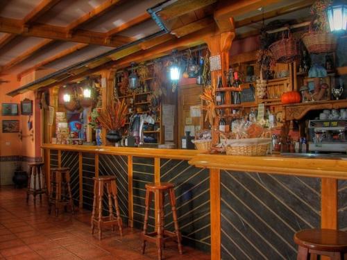 un bar en un restaurante con taburetes en una habitación en Complejo Rural Agoga de Las Médulas, en Las Médulas
