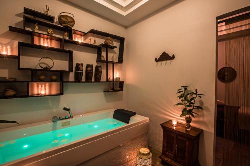 a bathroom with a large tub with blue lighting at Mane Boutique Hotel & Spa in Siem Reap