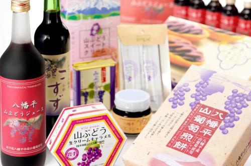 a table with a bottle of wine and a box of grapes at Hachimantai Mountain Hotel & Spa in Hachimantai
