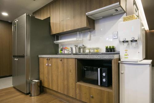 a kitchen with a refrigerator and a microwave at Philstay Myeongdong Station in Seoul