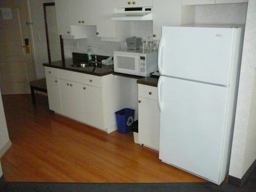 a kitchen with a white refrigerator and a microwave at Coast Abbotsford Hotel & Suites in Abbotsford