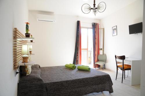 a bedroom with a bed with two green pillows on it at b&b Franzisca in Torpè