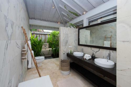 a bathroom with two sinks and a toilet at Villa Tranquilla in Nusa Lembongan