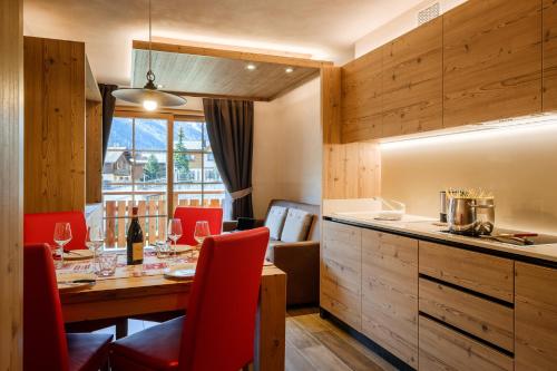 a kitchen and dining room with a table and red chairs at Chalet Bellavista in Livigno