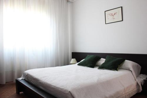 ein Schlafzimmer mit einem großen Bett mit grünen Kissen in der Unterkunft Marilide in Marotta