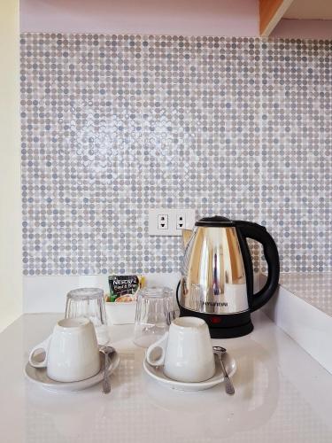 a tea kettle and cups on a kitchen counter at The Leaf House in Manila