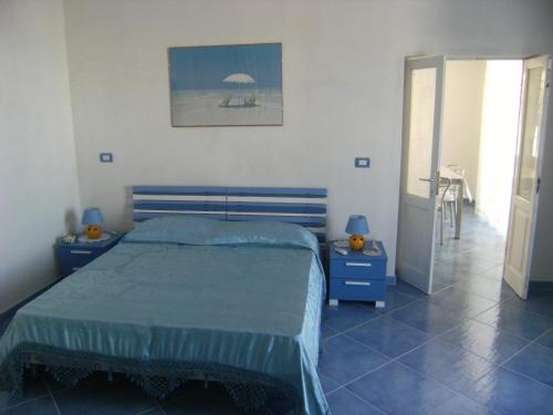 ポンツァにあるMagi - Begoniaのベッドルーム1室(ベッド1台、青いナイトスタンド2台付)