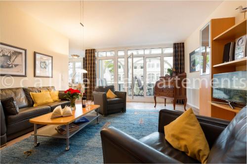 a living room with couches and a table at Villa Hildegard by Callsen in Binz