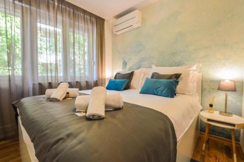 1 dormitorio con 1 cama grande con almohadas azules en Kolombo Lux apartment, en Split