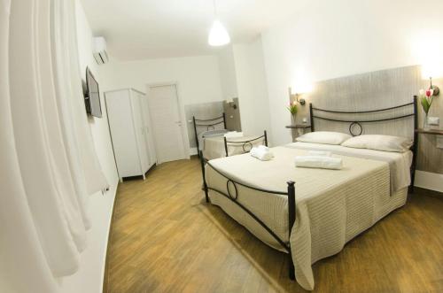 a bedroom with two beds with white sheets and wooden floors at Dimora degli Ulivi in Caprioli