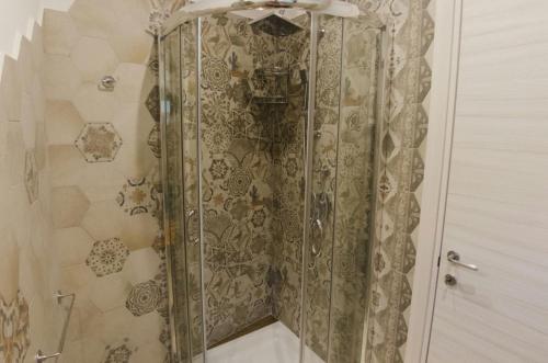 a shower with a glass door in a bathroom at Dimora degli Ulivi in Caprioli
