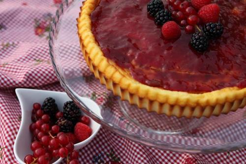 a pie on a glass plate with berries on a table at Agriturismo Casa Aurora in Bussolengo