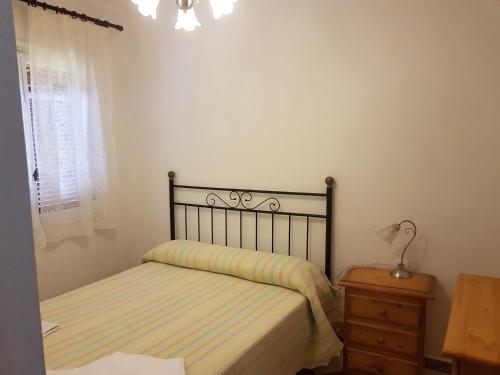 a bedroom with a bed and a dresser and a window at Las Belisas in Arenal d'en Castell