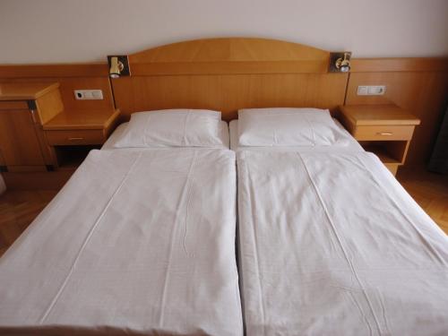 a bed with two pillows and two night stands at Ferienwohnung Rogatsch in Sankt Kanzian