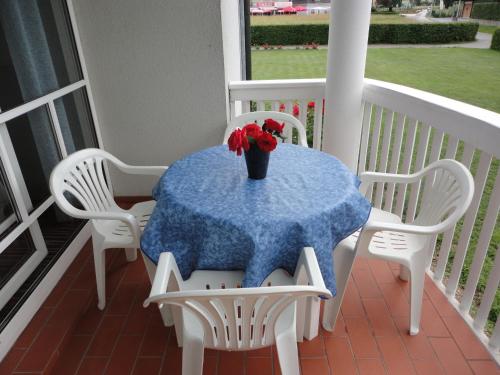 a table on a porch with a vase of flowers on it at Ferienwohnung Rogatsch in Sankt Kanzian