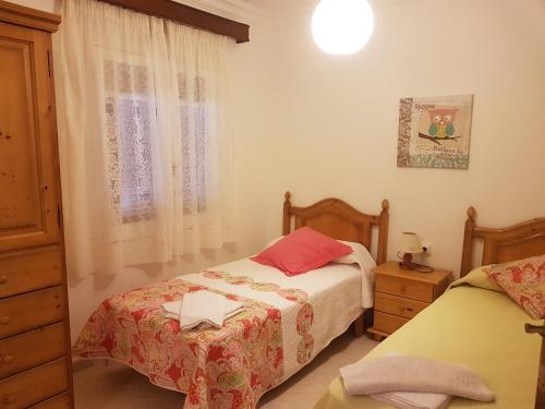 a bedroom with two beds and a window at Las Belisas in Arenal d'en Castell
