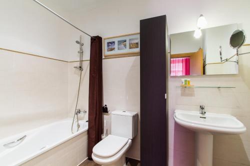 Living Valencia Apartments - Merced في فالنسيا: حمام به مرحاض أبيض ومغسلة