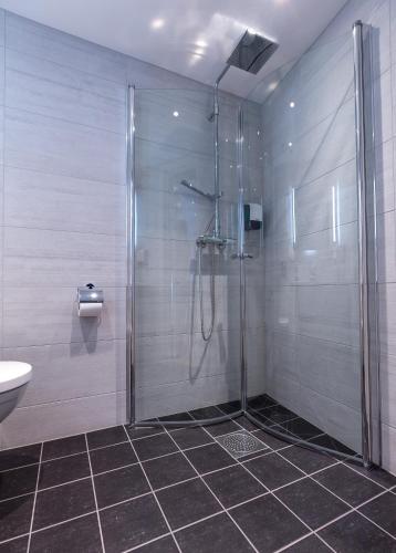 a bathroom with a shower and a toilet and a sink at Enter Amalie Hotel in Tromsø