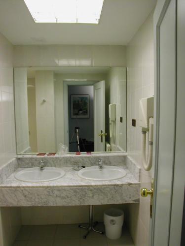 a bathroom with two sinks and a large mirror at Hotel Rey Sancho Ramírez in Barbastro