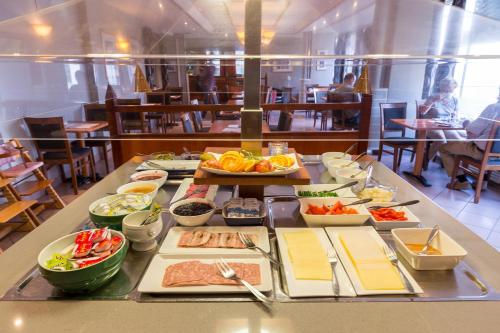 a buffet of food on a table in a restaurant at Enter Amalie Hotel in Tromsø