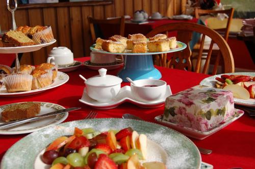 una mesa con platos de comida en una mesa roja en Findus House, Farmhouse Bed & Breakfast, en Macroom