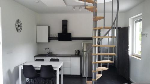 uma cozinha com uma mesa branca e uma escada em espiral em Domki Heaven Kujanki em Kujanki