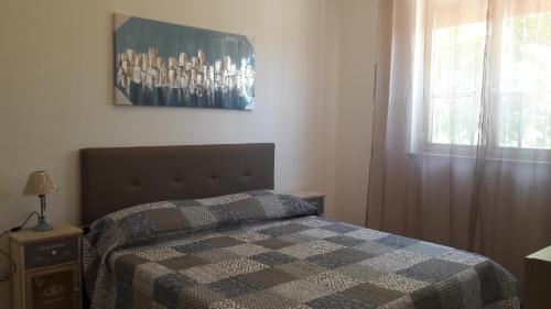 バレストラーテにあるCasa Vacanze Reginotteのベッドルーム1室(チェック入りの毛布、窓付)