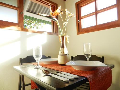 una mesa con un plato y un jarrón con flores en Pousada Ilha da Magia, en Florianópolis