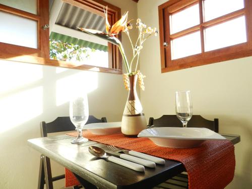 a table with a plate and a vase with flowers at Pousada Ilha da Magia in Florianópolis
