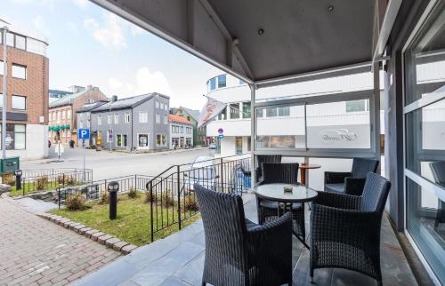 a balcony with chairs and a table and a street at Enter Amalie Hotel in Tromsø