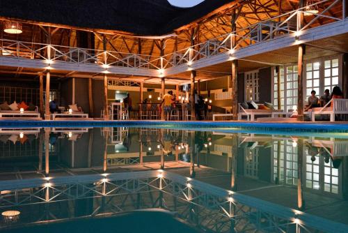 a swimming pool in a building with people sitting at Pili Pili Boutique Hotel in Kigali