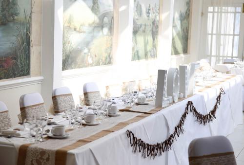 a long table in a room with white tablecloths at Quorn Country Hotel Leicester in Loughborough