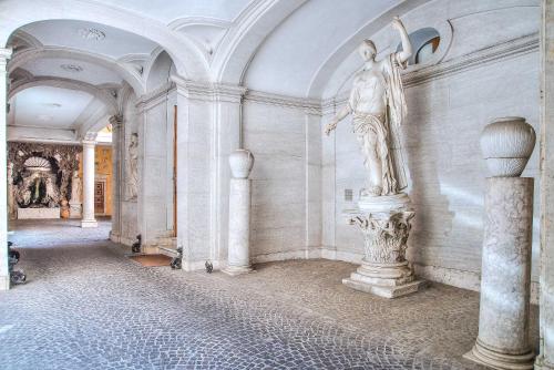 a statue of a man on a wall in a room at Trevi Rome Suite in Rome