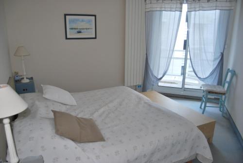 - une chambre avec un lit blanc et une fenêtre dans l'établissement Appartement La Baule Plage, à La Baule